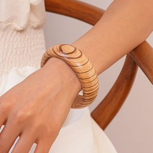Macro detail of wide wooden bangle showing natural wood grain and tree ring textures