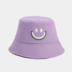 Close-up of purple cotton bucket hat featuring a white smiley face and twill texture