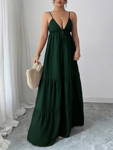 Detail of elegant deep green maxi dress with spaghetti straps and ruffled tiered skirt