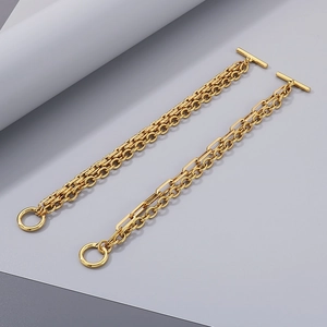 Detail of gold Cuban link and paperclip chain bracelets with vintage toggle clasp