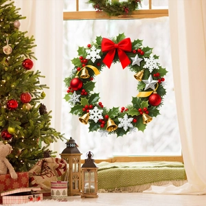Detailed view of a Christmas wreath with pine needles, red bows, and gold bells on a window