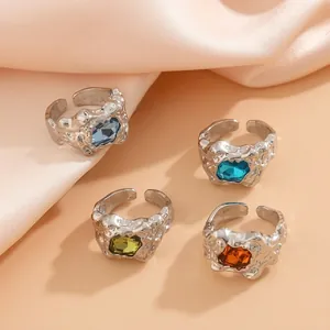 Dettagli di anelli in argento con trama lavica e pietre preziose rettangolari colorate