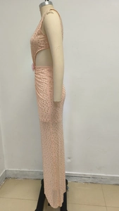 Détail d'une robe de soirée rose à paillettes avec découpe à la taille et perlage brillant