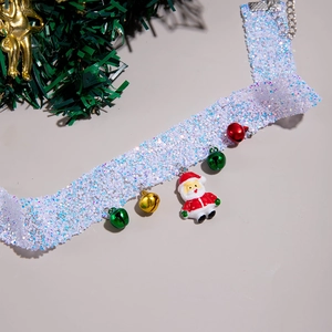 Detail shot of white lace choker with Santa Claus pendant and festive red green bells