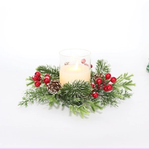 Macro view of Christmas candle ring with snowy pine needles, red berries, and pine cones