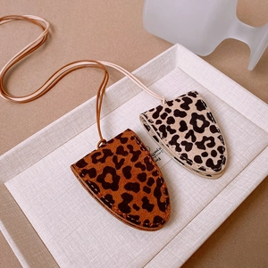 Detailed close-up of leopard print faux leather necklace pouches with fine stitching details