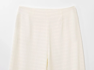 Dettaglio della vita alta e del tessuto seersucker strutturato in elegante bianco crema