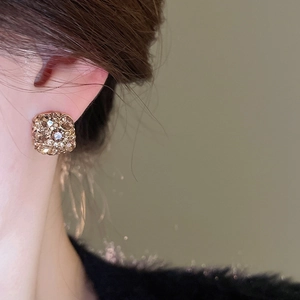 Detail view of vintage square pavé stud earrings with gold plating and sparkling crystals