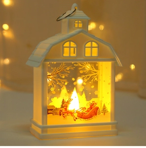 Detail of white house-shaped LED Christmas lantern with warm flickering candle light effect