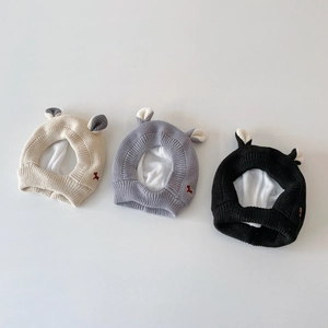 Vue détaillée de bonnets en tricot souple avec cache-oreilles en blanc, gris et noir