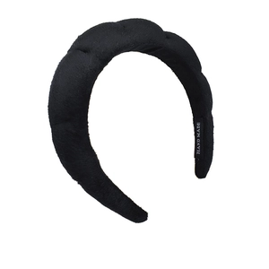 Detailed view of handmade black velvet braided headband with soft texture and inner label