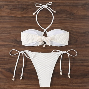 Detailed view of white waffle textured two-piece bikini with decorative shell charms