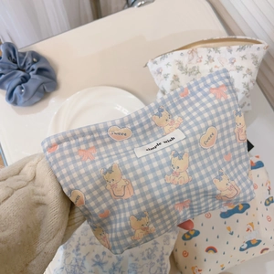 Detailed close-up of blue checkered makeup bag with teddy bear and zipper closure