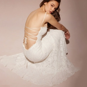 Détail de la robe maxi dos nu blanche avec bretelles croisées et texture dentelle florale