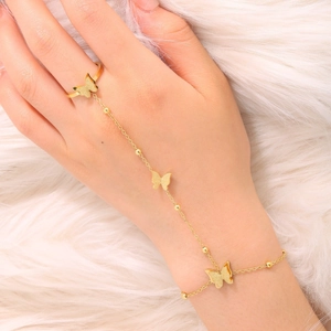 Elegant gold butterfly ring bracelet combo on model with white plush background decor