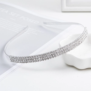 Elegant silver bridal headband with three rows of sparkling rhinestones on white background