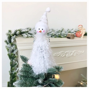 Close-up of white plush snowman tree topper with sequined pointed hat on Christmas tree