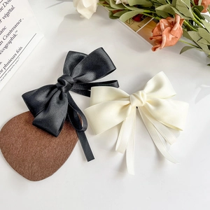 Elegant ribbon bow hair clips in black and cream beige with long flowing streamers