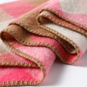 Close-up detail of cashmere-like pink brown plaid scarf with refined stitched edges