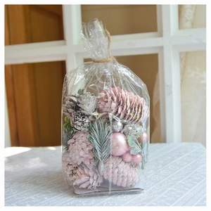 Christmas DIY kit with pink pine cones, silver berries, and artificial pine on lace background