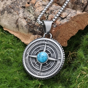 Viking compass pendant necklace with blue turquoise on moss and rustic wood background