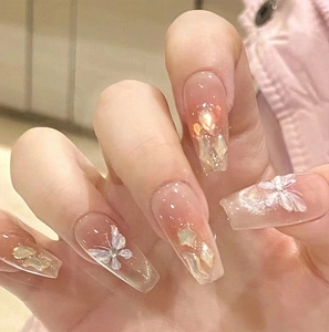 Detail of pink gradient press-on nails with 3D butterflies and aurora rhinestones