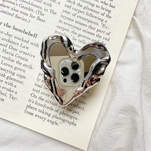 Detail of silver heart phone stand with liquid metal texture and mirror finish