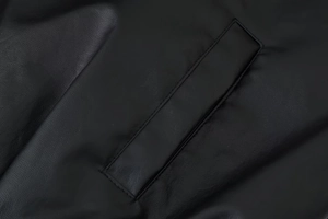 Close-up of a welt pocket and fine stitching on a vintage black leather jacket
