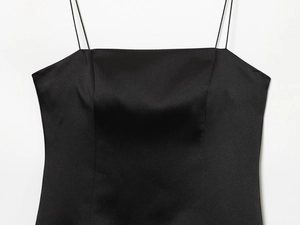 Détail rapproché de la robe en satin noir montrant la bordure en dentelle et bretelles
