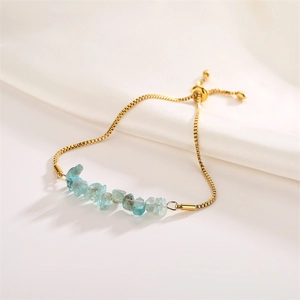 Detail of light blue crystal stone beads on a gold adjustable box chain bracelet