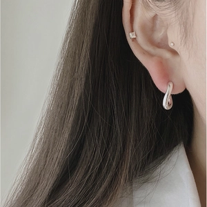 Close-up of minimalist S925 sterling silver curved U-shape earrings and diamond stud set