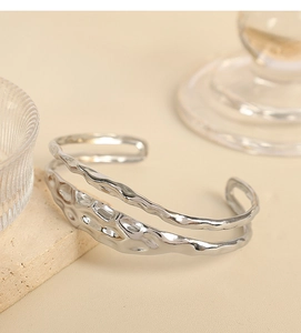 Detail of silver-plated titanium steel cuff featuring double-layered irregular lava textures