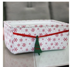 Detail of Christmas storage basket with snowflake patterns and Merry Christmas tag