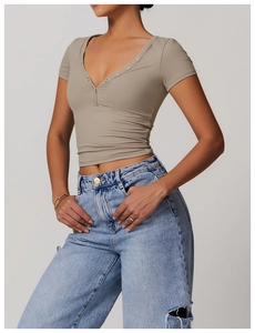 Close-up of V-neck yoga t-shirt with metallic button details and brushed fabric texture