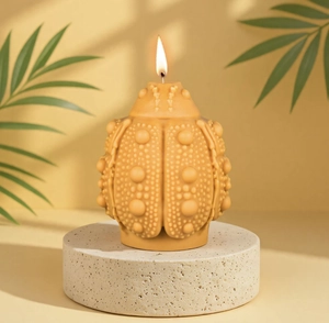 Detailed view of beetle-shaped aromatherapy candle with intricate texture and burning wick
