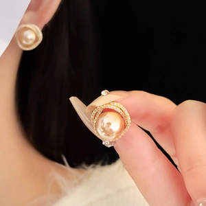 Close-up of champagne pearl earrings with gold hollow zircon rings and silver pins