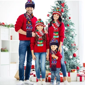 Famille portant des bonnets et écharpes de Noël tricotés à LED dans un décor festif
