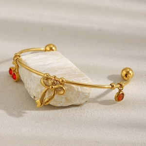 Vue détaillée du bracelet papillon doré 18 carats posé sur un support en pierre