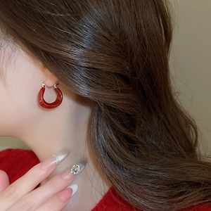 Gros plan de boucles d'oreilles en forme de U plaquées or 14K avec émail rouge