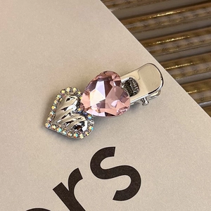 Detail of pink heart crystal and silver metal hair clip with AB rhinestones