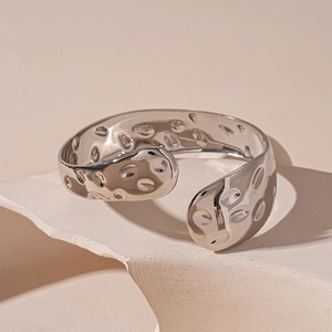 Dettaglio del bracciale rigido argento geometrico con trama martellata irregolare