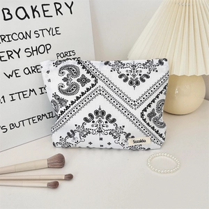 Vista dettagliata della borsa da trucco bianca con motivo paisley ed etichetta Sozakka