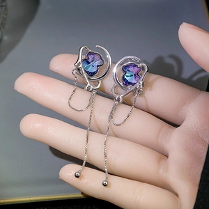 Detailed view of silver long fringe earrings with gradient heart crystal and moon star frame