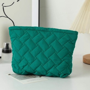 Detailed view of the bright green quilted rhombic stitching on a soft cosmetic bag