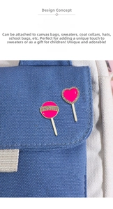 Pink enamel lollipop and heart brooch pins with rhinestones shown on a blue canvas bag