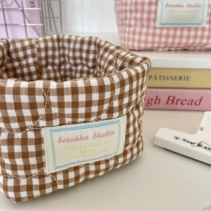 Close-up of quilted plaid fabric storage basket showing soft texture and fine stitching