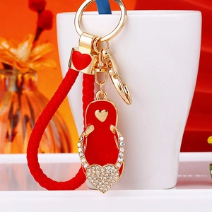 Detail of red flip-flop keychain with rhinestones and woven rope on a white ceramic cup