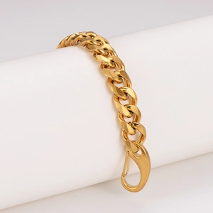 Polished gold stainless steel Cuban link bracelet with lobster clasp on display stand