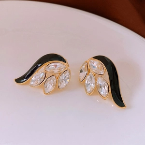 Close-up of vintage gold earrings with black enamel and marquise-cut crystals