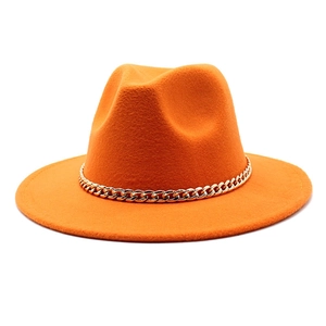 Close-up of bright orange wool fedora hat featuring a stylish gold Cuban chain band detail